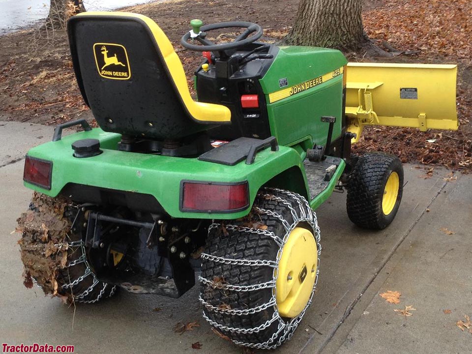 John Deere 425 with chains and front blade, rear view.